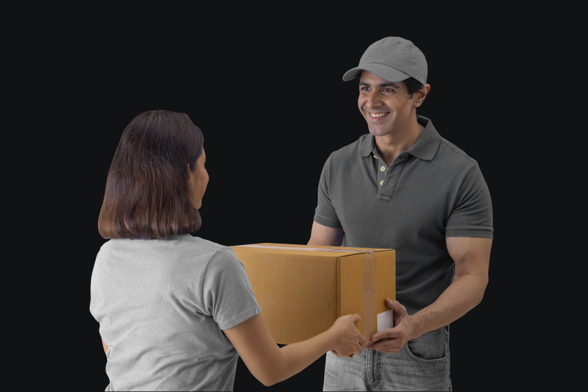 Helpful delivery person in casual attire hands box to smiling customer.