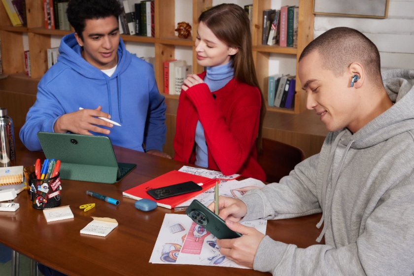 Three young adults studying and working together in a cozy library environment.